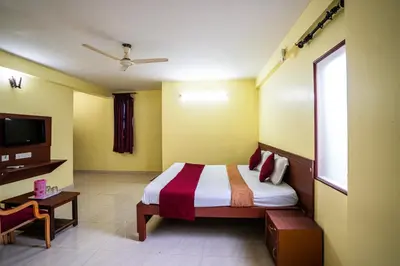 a bedroom with a bed and a television in it at Hotel Vyshak residency in Mysore