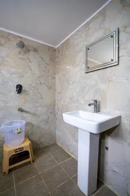 a bathroom with a sink and a mirror on the wall at Hotel Vyshak residency in Mysore