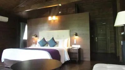a bedroom with a bed and a table in a room at The IBNII - Eco Luxury Resort in Madikeri