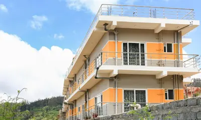 a building with orange and white balconies on it at Treebo Light House, 900 Mtrs From Botanical Garden in Ooty