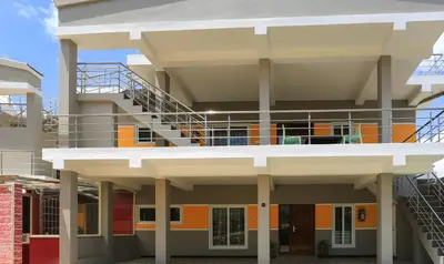 a building with a staircase in front of it at Treebo Light House, 900 Mtrs From Botanical Garden in Ooty
