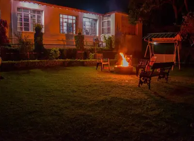 a fire in the yard of a house at night at Golf Dale Holiday Resort in Kotagiri