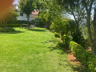 a yard with a bench and trees and grass at Golf Dale Holiday Resort in Kotagiri
