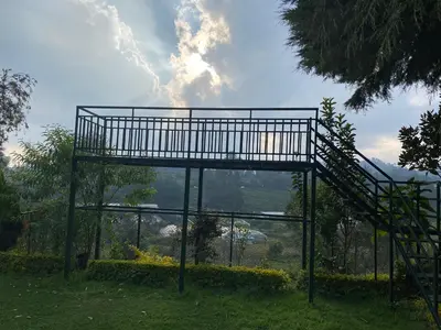 a metal structure with a staircase in the grass at Golf Dale Holiday Resort in Kotagiri