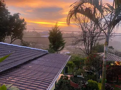 a view of a roof of a house at sunset at Golf Dale Holiday Resort in Kotagiri