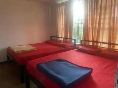 three beds in a room with a window at Golf Dale Holiday Resort in Kotagiri