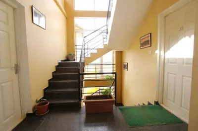 a hallway with stairs and a door with plants at The Hill Side in Ooty