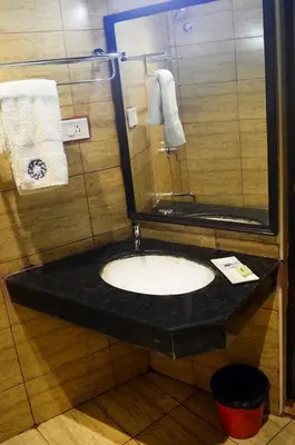 a bathroom with a black counter with a sink at Ranis Grand in Coimbatore