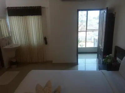 a bedroom with a bed and a door with a window at Ebenezer Plaza in Nedumbassery