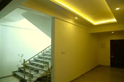 an empty room with a staircase and a yellow ceiling at Ebenezer Plaza in Nedumbassery