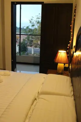 a bedroom with a bed with a lamp and a window at Ebenezer Plaza in Nedumbassery