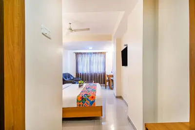 a bedroom with a bed and a table in a room at FabHotel Jansi Deluxe - Nr Gandhipuram Bus stand in Coimbatore
