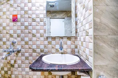 a bathroom with a sink and a mirror at FabHotel Jansi Deluxe - Nr Gandhipuram Bus stand in Coimbatore