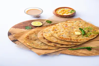 two pita breads on a wooden cutting board with sauce at FabHotel Jansi Deluxe - Nr Gandhipuram Bus stand in Coimbatore