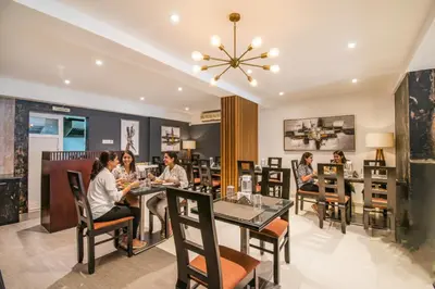 a group of people sitting at a table in a restaurant at FabHotel Jansi Deluxe - Nr Gandhipuram Bus stand in Coimbatore