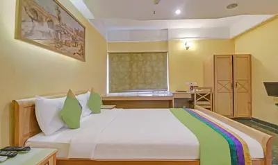 a bedroom with a large white bed with a window at Treebo Komfort Suites, 3 Km From Mysore Palace in Mysore