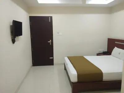 a bedroom with a bed and a door with a television at Dream Land Residency in Mananthavady