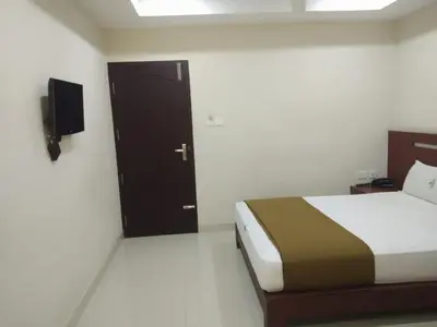 a bedroom with a bed and a door with a television at Dream Land Residency in Mananthavady