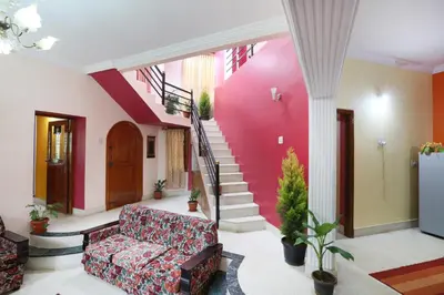a living room with a couch and stairs at LikeMyHome Homestay Mysore in Mysore