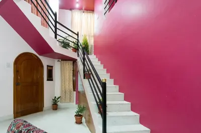 a staircase with a pink wall and a pink wall at LikeMyHome Homestay Mysore in Mysore
