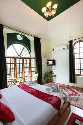 a bedroom with a large white bed with red pillows at LikeMyHome Homestay Mysore in Mysore