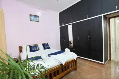 a bedroom with a bed with black cabinets at LikeMyHome Homestay Mysore in Mysore