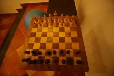 a wooden chess board with a game of chess at Mount Xanadu Resorts in Ambalavayal