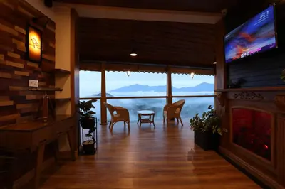 a living room with a table and chairs and a television at Mount Xanadu Resorts in Ambalavayal