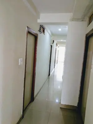 a hallway of an empty building with two doors at Hotel Ashwini Lodge in Mysore