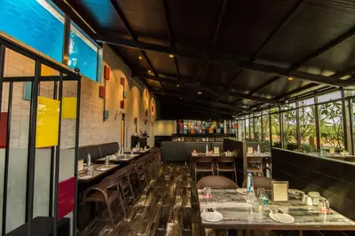 a dining room with tables and chairs and windows at Roopa Elite in Mysore
