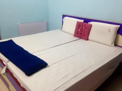 a bed with white sheets and pillows on it at Kvm Tourist Home in Palakkad