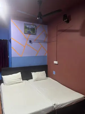 a large bed in a room with a wall at Kvm Tourist Home in Palakkad