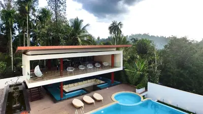 a building with a swimming pool next to a resort at Le Villagio Resort & Domes in Sultan Bathery