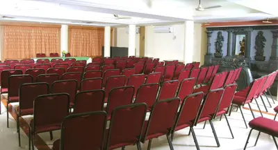 an empty lecture hall with red chairs in it at Sree Gokulam Sabari in Guruvāyūr