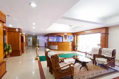 a large living room with chairs and a table at Sree Gokulam Sabari in Guruvāyūr