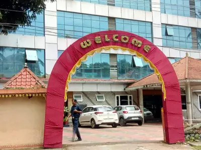 a man standing under a red arch in front of a building at Sree Gokulam Sabari in Guruvāyūr