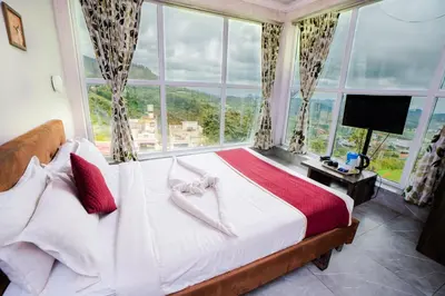 a bedroom with a bed with a large window at Tulips Valley View Resorts in Ooty