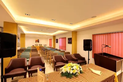 a conference room with chairs and tables and a podium at Park Residency Koyilandi in Quilāndi