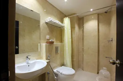 a bathroom with a sink and a toilet and a shower at Park Residency Koyilandi in Quilāndi