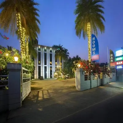 a large building with palm trees in front of it at Park Residency Koyilandi in Quilāndi
