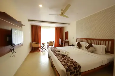 a hotel room with a large bed and a television at Park regency in Angamali