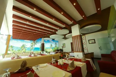 a restaurant with tables and a view of the ocean at Park regency in Angamali
