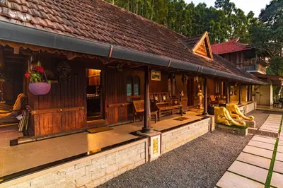 a wooden house with a porch with bananas on it at Castillo De Woods , The Private Luxury Villa , 8 BHK, Vattavada in Kottakamboor
