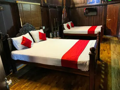 two beds with red and white sheets in a room at Castillo De Woods , The Private Luxury Villa , 8 BHK, Vattavada in Kottakamboor