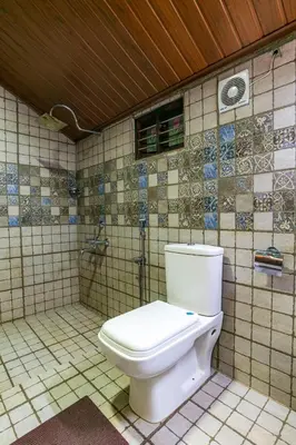 a bathroom with a toilet in a tiled room at Castillo De Woods , The Private Luxury Villa , 8 BHK, Vattavada in Kottakamboor