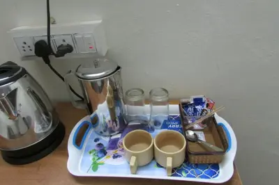 a tray with cups and a coffee maker on a counter at Greenwoods Nature Camp in Mudumalai National Park