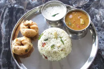 a plate of food with rice and a bowl of soup at Greenwoods Nature Camp in Mudumalai National Park