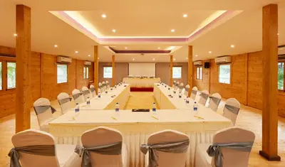 a large room with tables and chairs in it at Sterling Anaikatti in Varagampadi