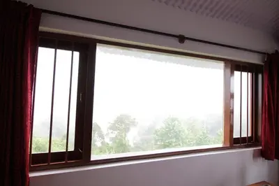 a large window in a room with a view at Satya Anand Cottage Pure Veg and Non Alcoholic Hotel in Coonoor