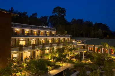 an exterior view of a building at night at Purple Palms Resort & Spa in Kushālnagar